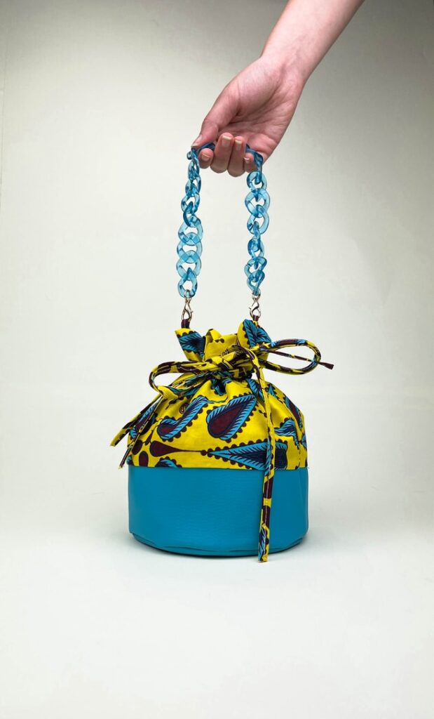Borsa limone in stoffa wax con fondo in ecopelle turchese e catena in azzurro come manico e ganci color oro scatto 1