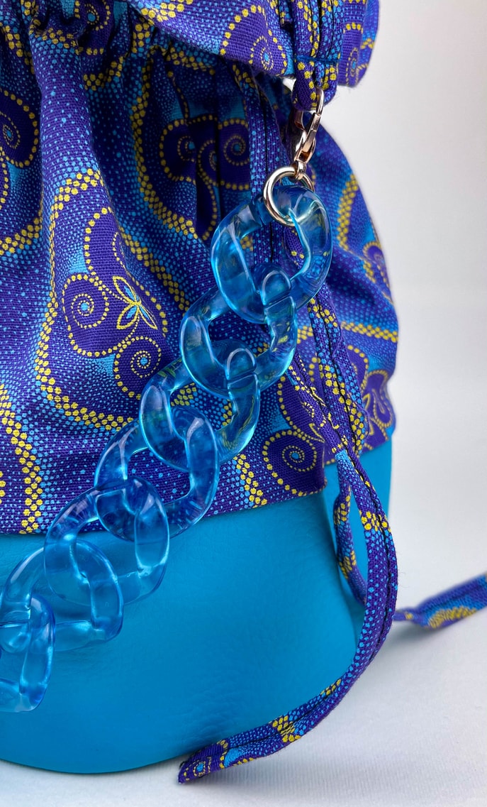 Borsa vento in stoffa shweshwe con fondo in ecopelle azzurro intenso e catena dello stesso colore come manico con ganci in color oro scatto 3